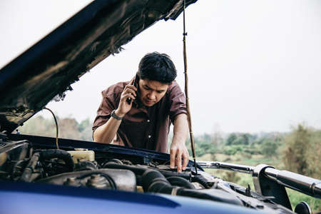 Man try to fix a car engine problem on a local road Chiang mai Thailand - people with car problem...