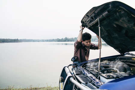 Man try to fix a car engine problem on a local road Chiang mai Thailand - people with car problem...