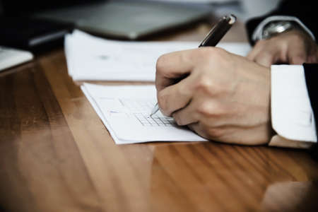 Instructor checking multiple choices answer sheet exam - education people working with paper test conceptの写真素材