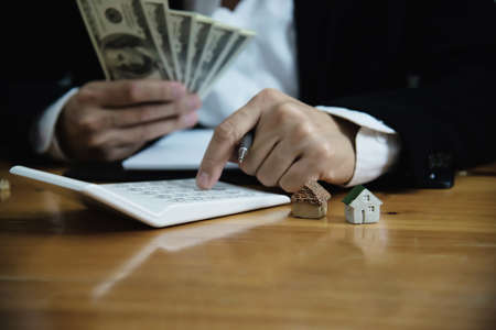 Business man show money bank note make financial plan invite people to sell or buy house and car - monetary properties loan credit insurance conceptの写真素材