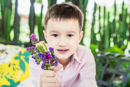 Boy enjoy playing with flower and cactus in a restaurant - boy happy with nature conceptの写真素材