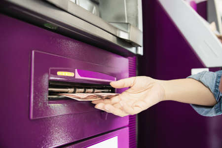 People waiting to get money from automated teller machine - people withdrawn money from ATM conceptの写真素材