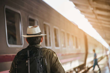Travel man wait train at platform - people vacation lifestyle activities at train station transportation conceptの写真素材