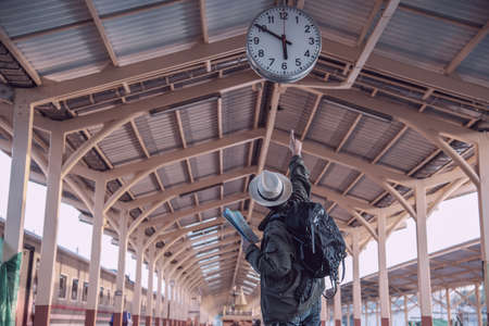 Travel man wait train at platform - people vacation lifestyle activities at train station transportation conceptの写真素材