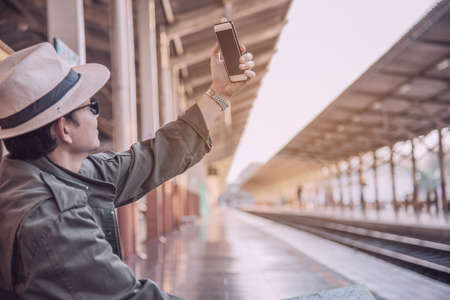 Travel man wait train at platform - people vacation lifestyle activities at train station...