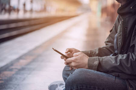 Travel man wait train at platform - people vacation lifestyle activities at train station transportation conceptの写真素材