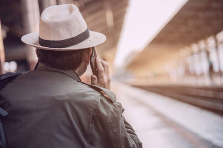 Travel man wait train at platform - people vacation lifestyle activities at train station transportation conceptの写真素材