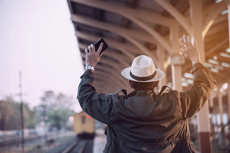 Travel man wait train at platform - people vacation lifestyle activities at train station transportation conceptの写真素材