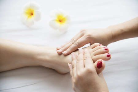Woman receiving foot massage service from masseuse close up at hand and foot - relax in foot massage therapy service conceptの写真素材