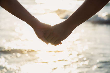 Asian couple is holding hand near to the seaの写真素材