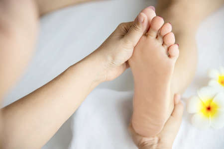 Woman receiving foot massage service from masseuse close up at hand and foot - relax in foot massage therapy service conceptの写真素材