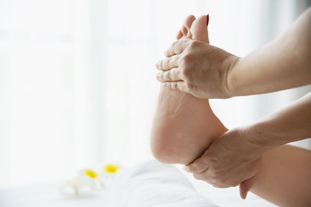 Woman receiving foot massage service from masseuse close up at hand and foot - relax in foot massage therapy service conceptの写真素材