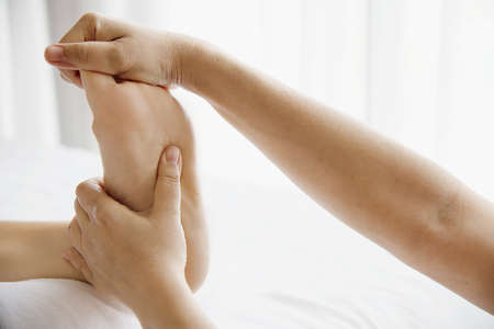 Woman receiving foot massage service from masseuse close up at hand and foot - relax in foot massage...
