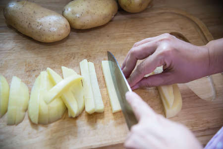 People cooking fresh potato preparing food in the kitchen - potato cooking conceptの写真素材