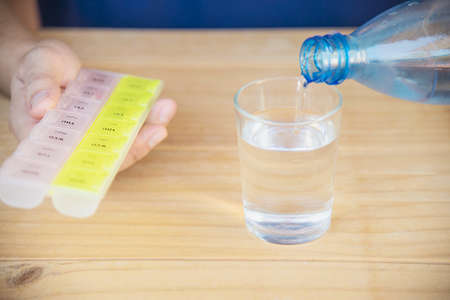 Man is going to eat medicine tablet - people with medical health problem conceptの写真素材