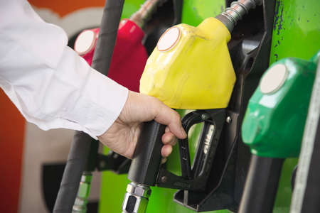Man putting gasoline fuel into his car in a pump gas station