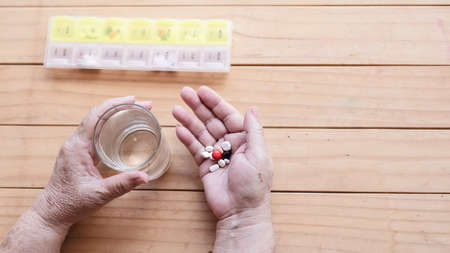 Old lady prepare to eat daily medicine pill - people healthcare with medicine pills conceptの写真素材