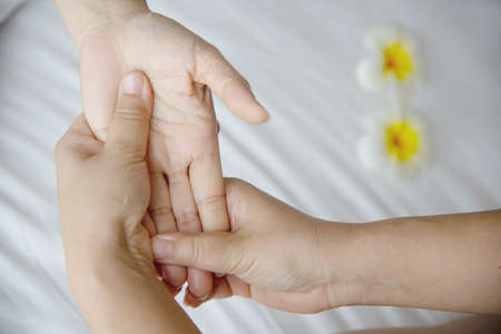 Hand spa massage over clean white bed background - people relax with hand massage serviceの写真素材