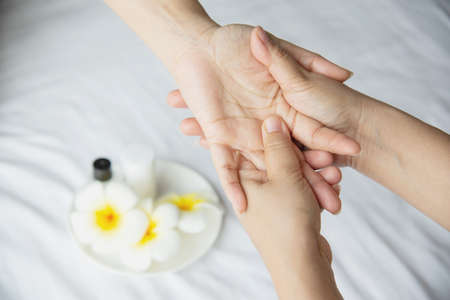 Hand spa massage over clean white bed background - people relax with hand massage serviceの写真素材