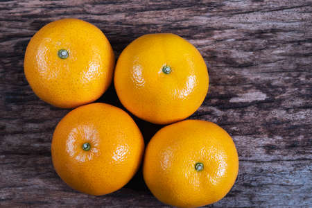 Fresh juicy orange fruit set on old wooden texture plank - tropical orange fruit for background useの写真素材