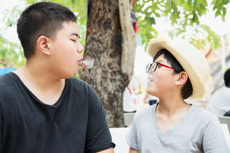 Asian boy eating smoking canny happily - people and snack happy time concept