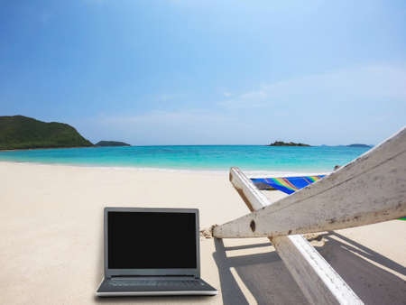 Relax beach chair with laptop on clean sand beach with blue sea and clear sky - sea nature background relax working holiday conceptの写真素材