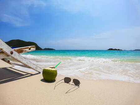 Relax beach chair with fresh coconut on clean sand beach with blue sea and clear sky - sea nature background relax conceptの写真素材