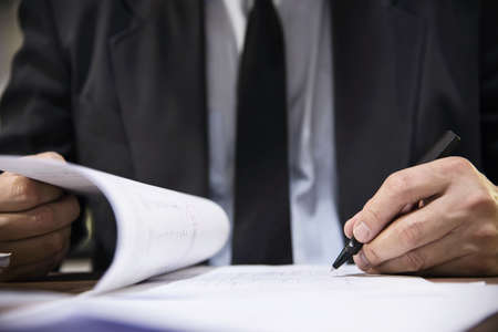 Businessman holding pen while working with document - business people working conceptの写真素材