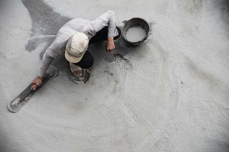 Construction man working with cement floor finishing - fresh concrete  work with construction hand...