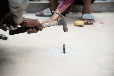 Workman is setting level for concrete floor pouring - man working in construction site concept