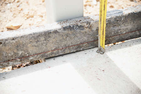 Construction worker doing his job -  using measuring tape preparing to pour concrete floor