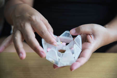 Woman prepare to eat periodical daily medicine pill - people healthcare with medicine pills conceptの写真素材