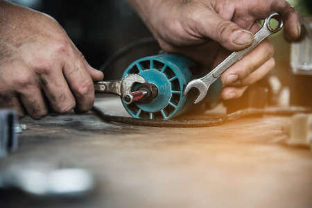 Man preparing electric router laminate trimmer machine tool - carpenter workshop concept