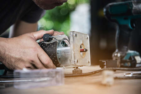 Man preparing electric router laminate trimmer machine tool - carpenter workshop conceptの写真素材