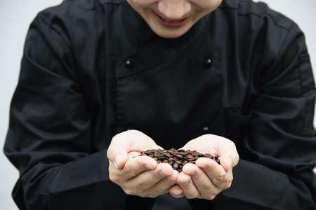 Barista is smiling why holding rosted coffee bean ready for making coffee cupの写真素材