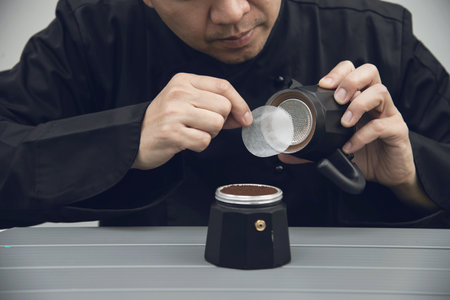 Asian barista is making hot coffee using moka potの写真素材