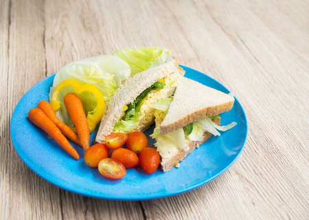 Sandwich egg with fresh vegetables salad breakfast backgroundの写真素材