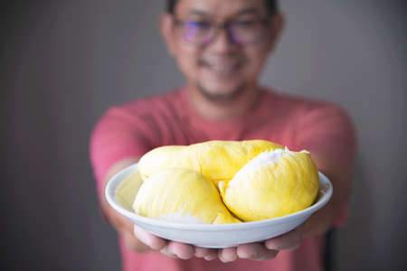 Asian man showing ripe durian happilyの写真素材