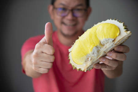 Asian man showing ripe durian happilyの写真素材