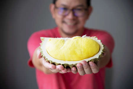Asian man showing ripe durian happilyの写真素材