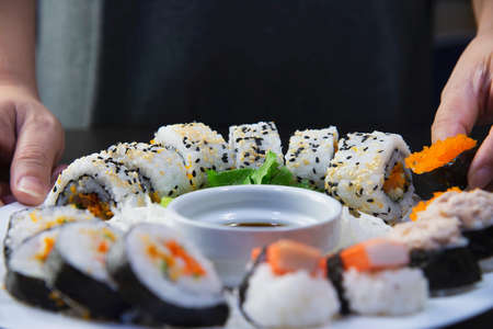 japanese sushi roll serving in oriental restaurant, chef is preparing japan tradition cookery menu, various different assorted luxury mixed healthy eating set conceptの写真素材