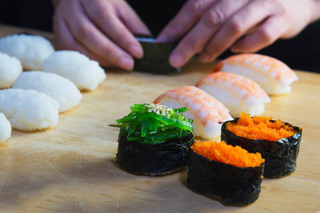 japanese maki sushi roll serving in oriental restaurant, chef is preparing japan tradition cookery menu, various different assorted luxury mixed healthy eating set conceptの写真素材