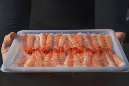 chef is preparing sushi shrimp for making japan cookery menu, japanese maki sushi roll serving in oriental restaurant, various different assorted luxury mixed healthy eating set conceptの写真素材
