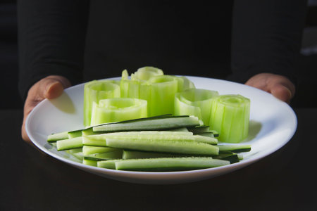chef is preparing fresh cucumber for making japan tradition cookery menu, japanese maki sushi roll serving in oriental restaurant, various different assorted luxury mixed healthy eating set conceptの写真素材