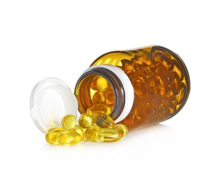 Fish oil capsules and container on white backgroundの写真素材