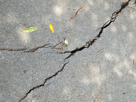 Old wet worn and cracked asphalt with cracks の写真素材