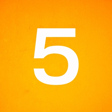 close up on white stenciled number five on yellow wallの写真素材