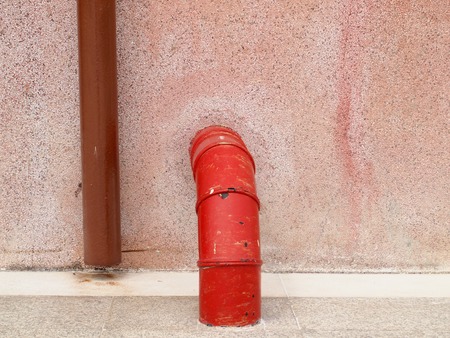 plumbing pipe against stucco wall , industrial grunge の写真素材