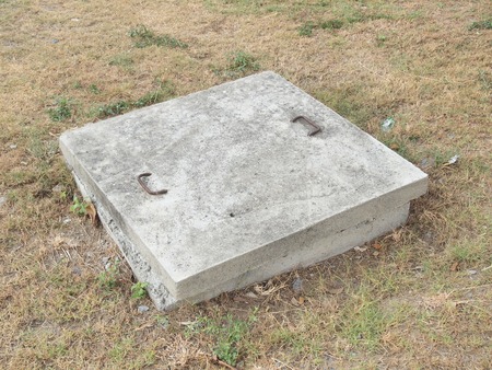 Sewer manhole on the urban asphalt roadの写真素材