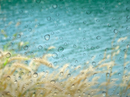 close up drops of rain on glass background. river out of focusの写真素材